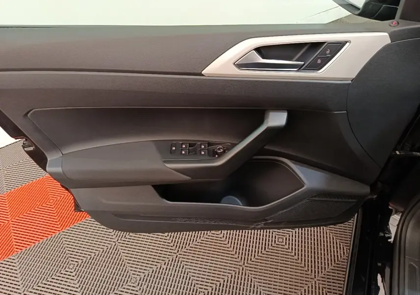 Vue intérieure côté gauche de la porte avant noire d'une Volkswagen Polo 2020 avec commandes de vitres et verrouillage.
