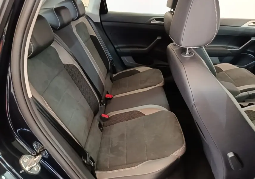 Vue intérieure côté gauche montrant la banquette arrière en tissu gris et noir de la Volkswagen Polo noire 2020.