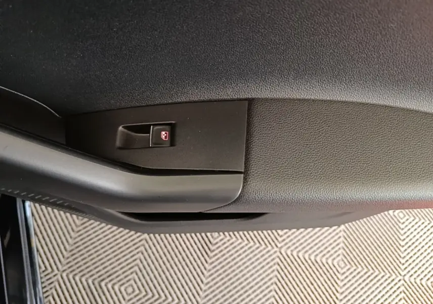 Détail de la poignée intérieure de porte côté conducteur de la Volkswagen Polo noire, avec bouton de verrouillage.