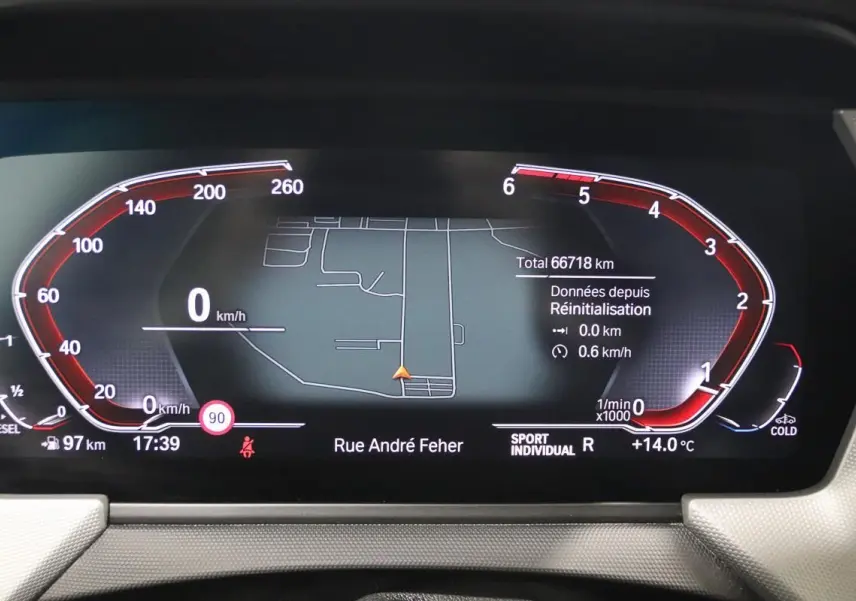 Tableau de bord numérique BMW Série 1 116d noir, affichant la navigation GPS et les compteurs en mode Sport Individual.