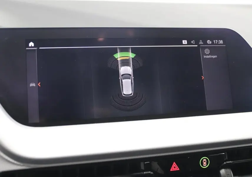 Écran central de BMW Série 1 116d 2023 montrant l'alerte de proximité avant avec vue du dessus du véhicule.