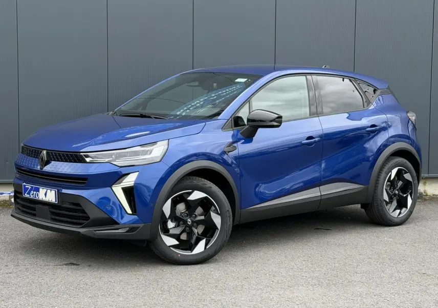 Renault Captur 2026 bleu Iron en 3/4 avant droit, avec jantes aluminium noires et rétroviseurs noirs brillants.