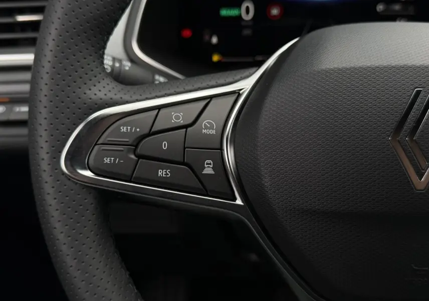 Gros plan sur le volant en textile noir du Renault Captur 2026, avec commandes intégrées côté gauche.