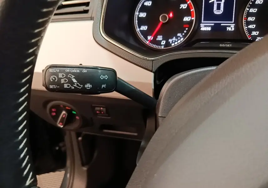 Gros plan sur le commodo gauche du volant d’une SEAT Arona 2019, tableau de bord avec compteurs et affichage digital.