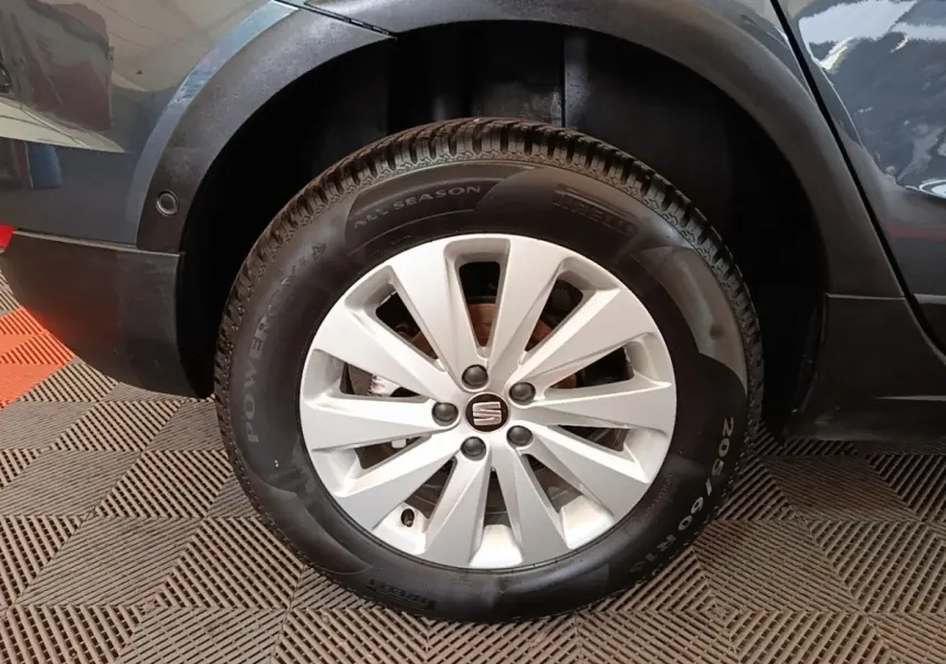 Gros plan sur la roue avant droite d’un SEAT Arona gris clair avec jante alliage et pneu Pirelli all season.