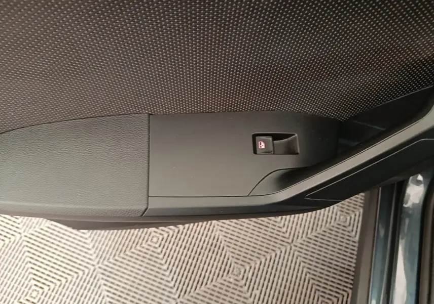 Détail de la poignée intérieure de porte côté conducteur du SEAT Arona gris clair, avec bouton de verrouillage.