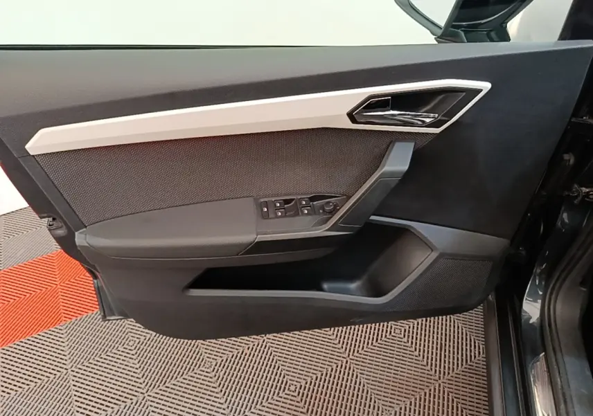 Vue rapprochée de la porte avant gauche d’un SEAT Arona 2019 avec garniture noire et insert gris clair.