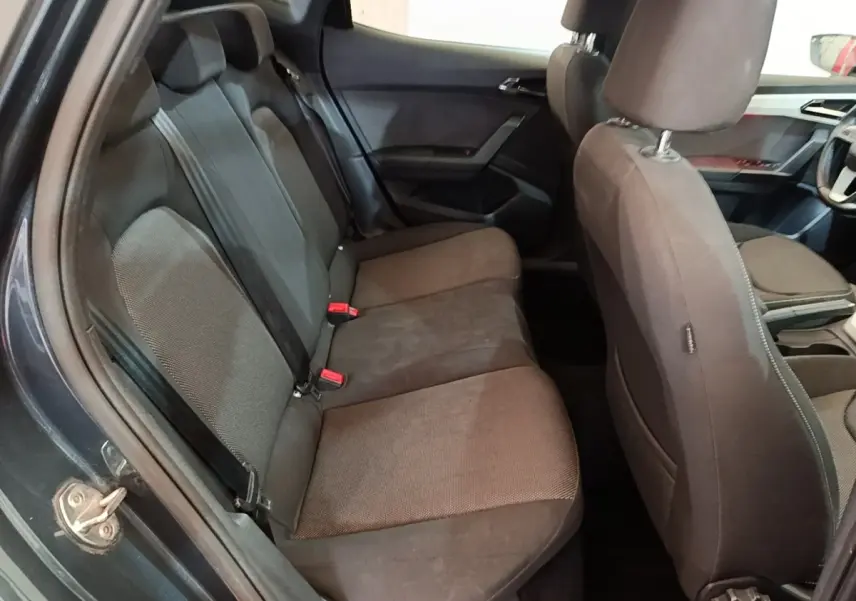 Vue intérieure côté gauche montrant la banquette arrière et les sièges avant gris foncé du SEAT Arona 2019.