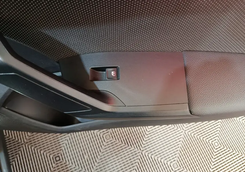 Détail de la poignée intérieure de porte côté conducteur du SEAT Arona gris clair, avec bouton de verrouillage.