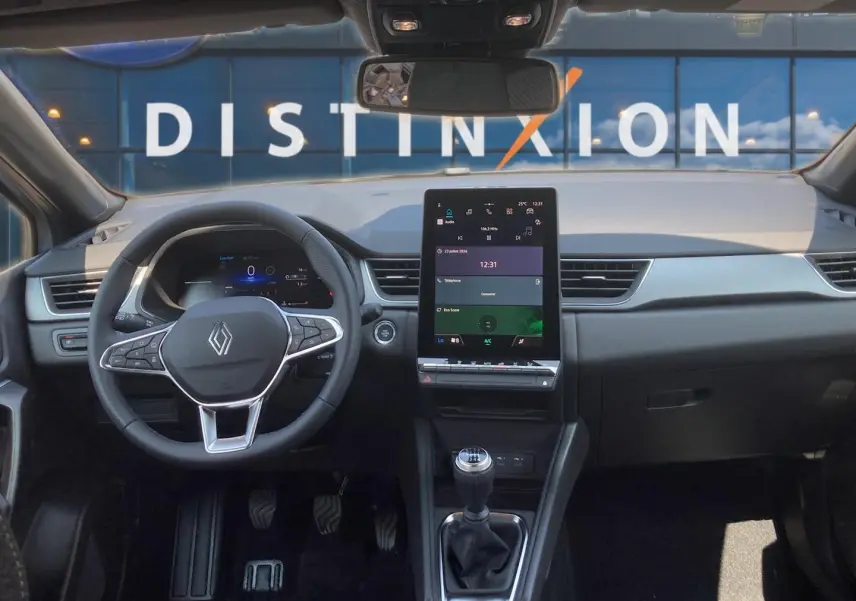 Vue intérieure avant du Renault Captur 2026 avec volant multifonction, écran tactile vertical et levier de vitesse manuel.
