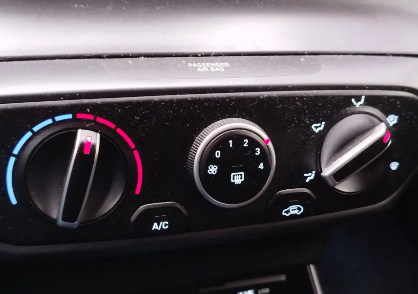 Gros plan sur les commandes de climatisation du Hyundai Bayon 2022 en couleur Elemental Brass Metal, avec réglages température et ventilation.