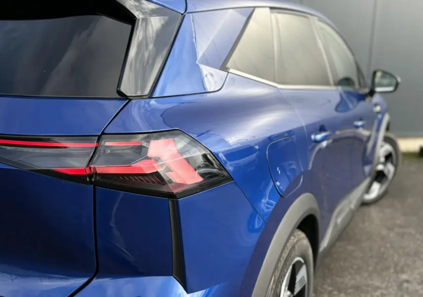 Vue 3/4 arrière droite sur Renault SYMBIOZ bleu Iron, mettant en valeur les feux LED et la carrosserie brillante.