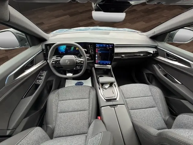 Vue intérieure avant du Renault Austral 2026 bleu, tableau de bord moderne avec écran tactile vertical et volant multifonctions.