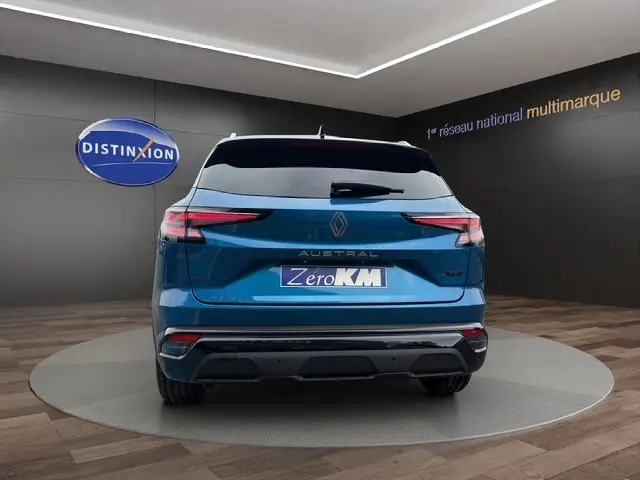Vue arrière d'un Renault Austral bleu bi-ton avec hayon motorisé et logo RS visible en showroom.