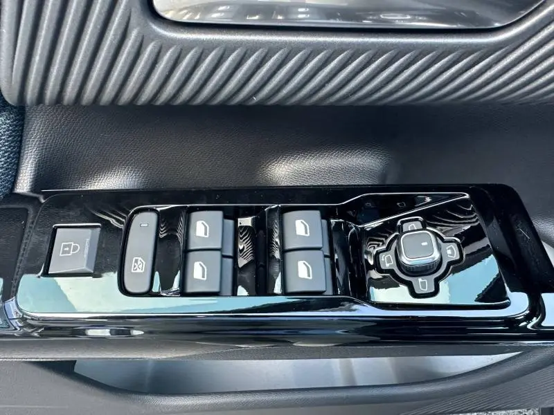 Gros plan sur les commandes de lève-vitres et rétroviseurs noirs brillants côté conducteur du Citroën C5 Aircross gris Platinium.