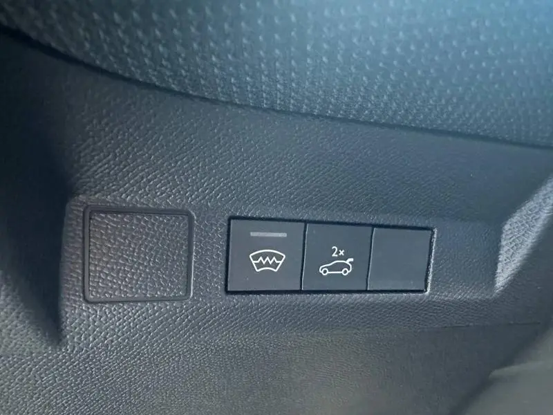 Gros plan sur les boutons de commande noirs du hayon et dégivrage arrière dans l’habitacle du Citroën C5 Aircross gris Platinium.
