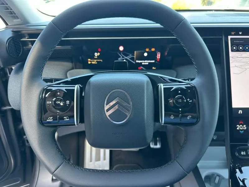 Vue rapprochée du volant multifonction noir du Citroën C5 Aircross 2026 avec affichage numérique et écran tactile.