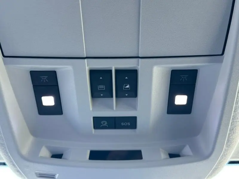 Vue rapprochée du panneau de commandes de plafonnier gris clair avec boutons d’éclairage et SOS du Citroën C5 Aircross 2026.