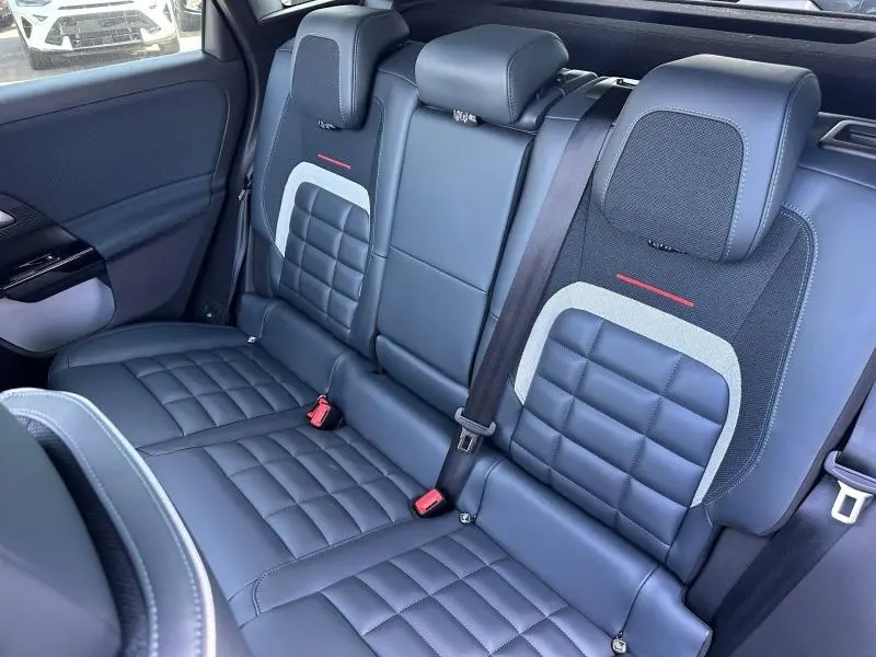 Vue intérieure côté arrière droit des sièges en cuir noir et tissu bleu avec surpiqûres et accoudoir central rabattable du Citroën C5 Aircross.