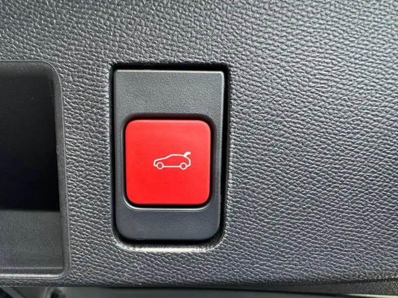Bouton rouge d'ouverture électrique du coffre sur tableau de bord noir texturé d'une Citroën C5 Aircross 2026.