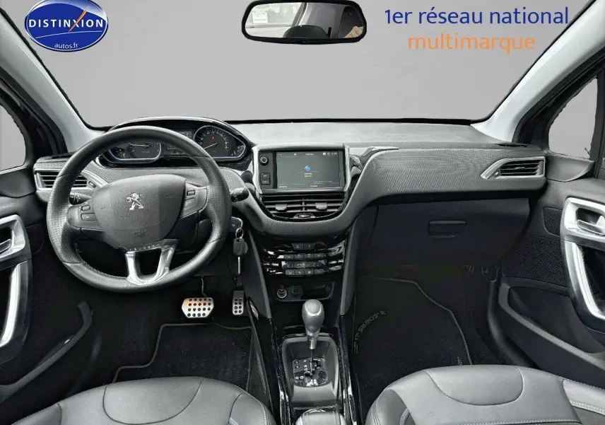 Vue intérieure avant de la Peugeot 2008 gris platinium de 2019, avec tableau de bord moderne et volant cuir multifonction.