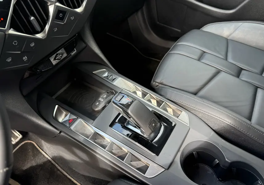 Gros plan sur la console centrale et le levier de vitesse automatique d'une DS3 2024, intérieur cuir noir.