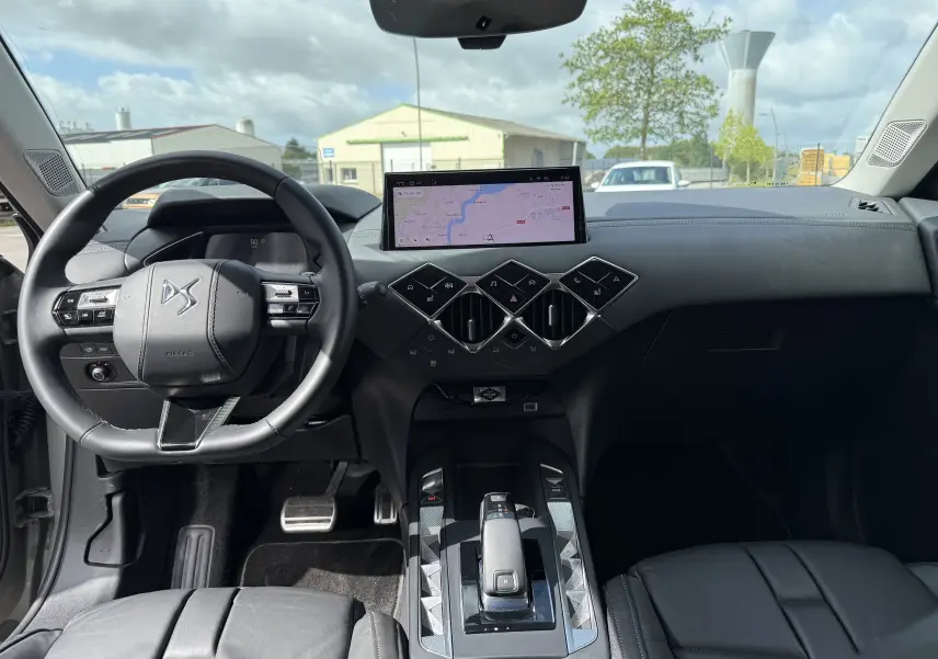 Intérieur de la DS3 2024 vue de face, tableau de bord noir avec écran tactile et volant cuir marqué DS.