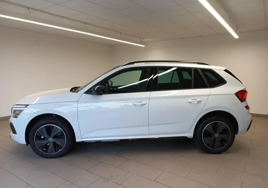 Vue de profil côté gauche du SUV blanc SKODA KAMIQ 1.5 TSI 150 DSG7 Monte-Carlo avec jantes noires distinctives.