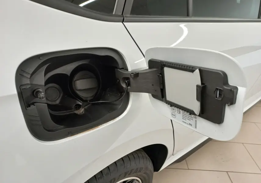 Vue rapprochée de la trappe à carburant ouverte côté gauche du Skoda Kamiq Blanc Lune 2025 avec bouchon essence visible.