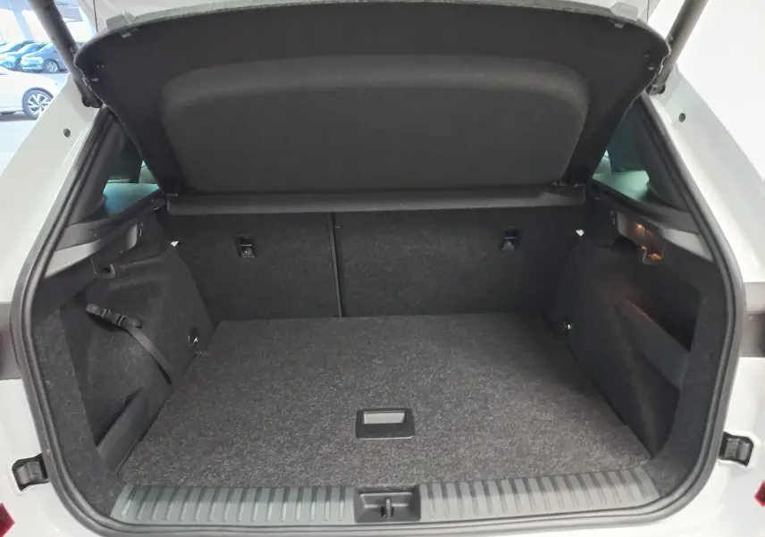 Coffre ouvert du Skoda Kamiq blanc Lune 2025, vue arrière montrant le double plancher et l'espace de rangement.