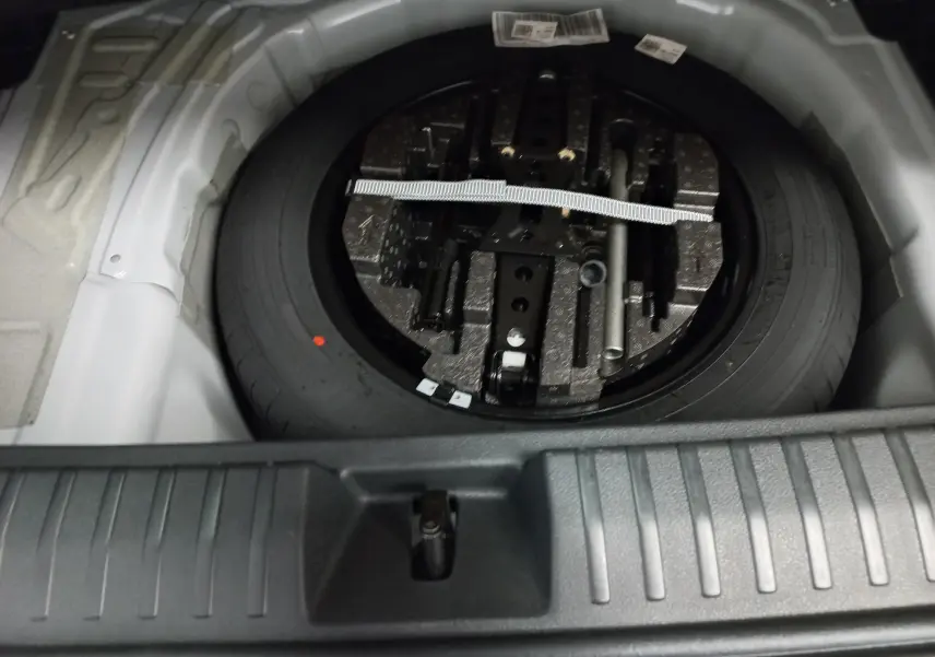 Gros plan sur la roue de secours et le double plancher du coffre du Skoda Kamiq 2025 Blanc Lune Monte-Carlo.