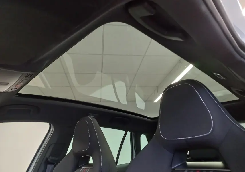 Toit panoramique en verre et sièges avant noirs avec surpiqûres blanches dans un Skoda Kamiq Blanc Lune 2025.