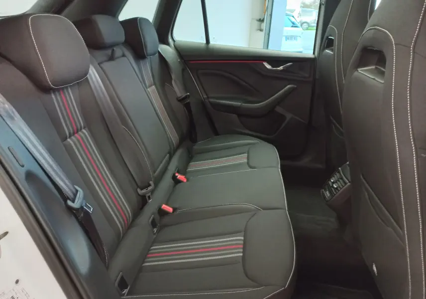 Vue latérale droite de l'habitacle arrière du Skoda Kamiq Monte-Carlo 2025 avec sièges noirs à bandes rouges et blanches.