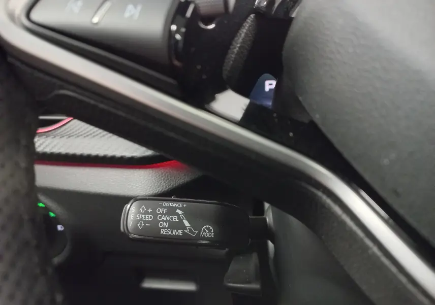 Gros plan sur la commande de régulateur de vitesse à gauche du volant du Skoda Kamiq blanc Lune 2025.