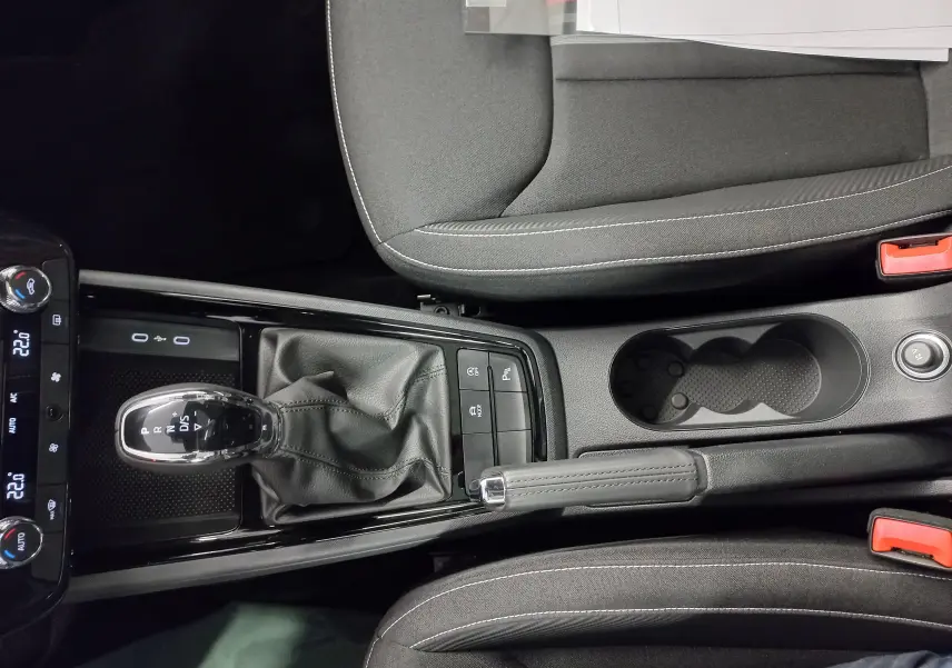 Vue plongeante sur la console centrale du Skoda Kamiq 2025 avec levier de vitesses DSG et frein à main manuel.