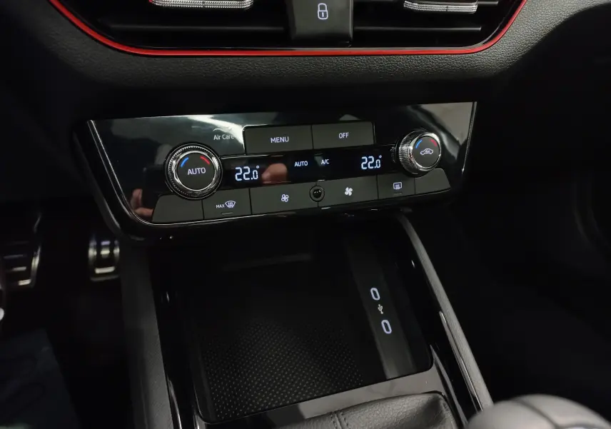 Gros plan sur la console centrale du Skoda Kamiq 2025 blanc Lune, avec commandes climatisation digitale et finition noire brillante.