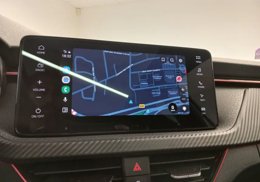 Écran tactile central du Skoda Kamiq 2025 montrant la navigation, avec finition carbone et touches tactiles latérales.