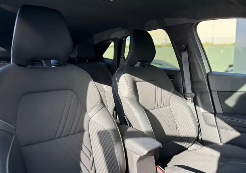 Vue intérieure des sièges avant en tissu gris avec coutures contrastées du Renault Symbioz E-Tech Full Hybrid 2025.