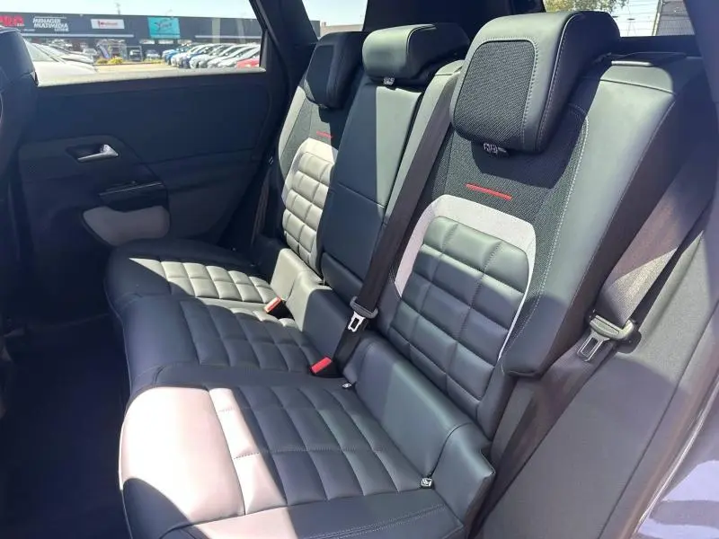 Vue intérieure des sièges arrière en cuir noir et tissu bleu du Citroën C5 Aircross 2026, avec ceinture de sécurité visible.