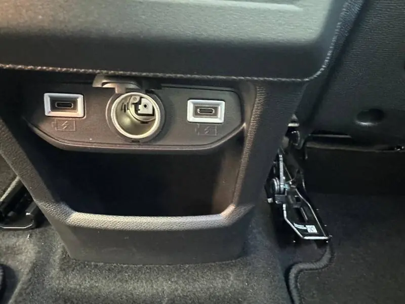 Prise 12V et deux ports USB visibles sur la console arrière noire du Citroën C5 Aircross gris Platinium.