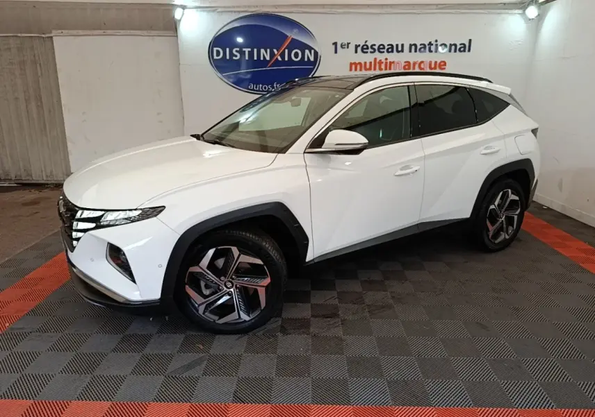 Hyundai Tucson 1.6 Hybrid 230 Executive blanc vu de profil droit en intérieur avec jantes distinctives et toit noir.