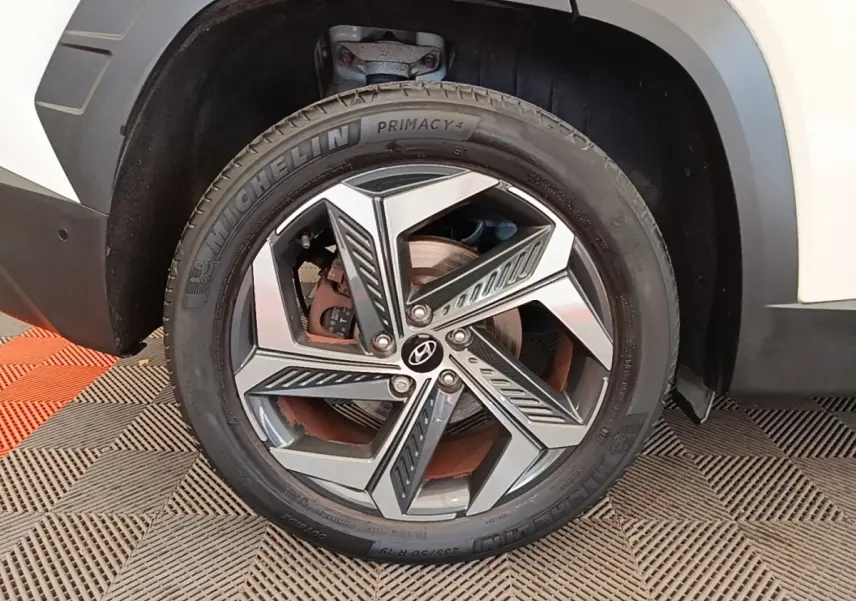 Gros plan sur la roue avant droite d’un Hyundai Tucson blanc, avec jante alliage moderne et pneu Michelin.