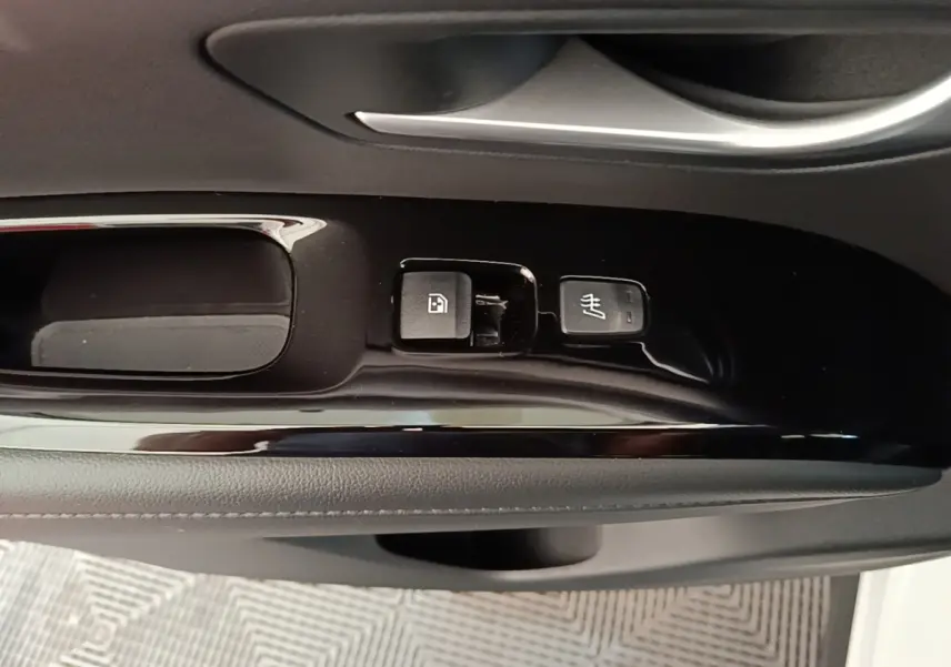 Détail intérieur montrant les commandes de lève-vitre et siège chauffant sur la porte côté conducteur d’un Hyundai Tucson blanc.