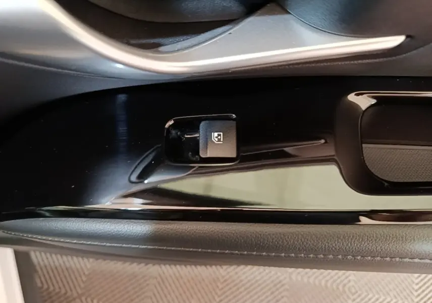 Gros plan sur la commande de verrouillage des portes côté conducteur du Hyundai Tucson blanc 1.6 Hybrid 230 Executive.