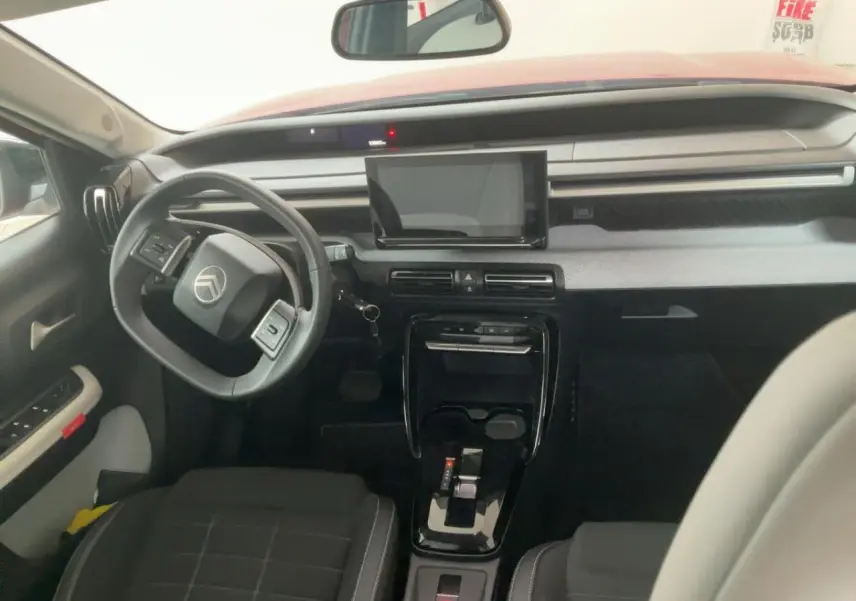 Vue intérieure avant de la Citroën C3 ë-113 Berline Max 2025, tableau de bord moderne avec écran tactile et volant multifonction.