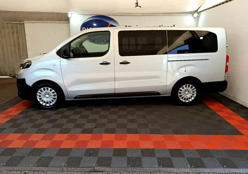 Profil latéral droit d'un Toyota Proace Verso gris clair 2019 avec vitres arrière teintées et jantes acier.