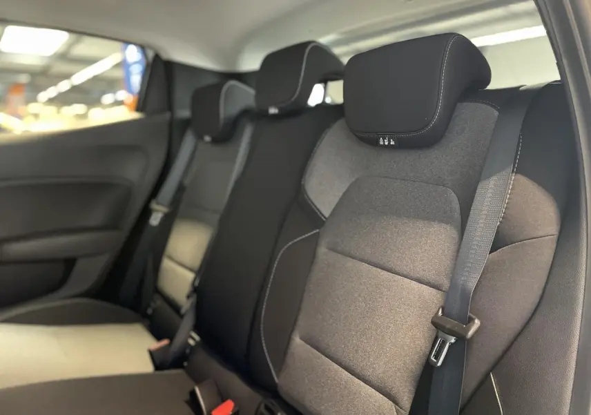 Vue intérieure des sièges arrière gris foncé avec ceintures de sécurité d'une Renault Clio blanche 2025.