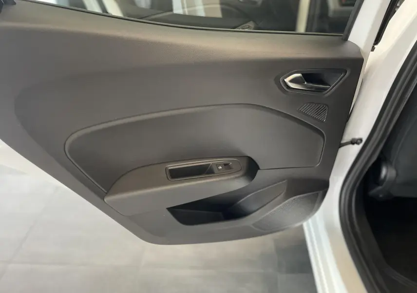 Porte intérieure côté arrière droit de la Renault Clio blanche 2025 avec commande de vitre électrique et poignée intégrée.