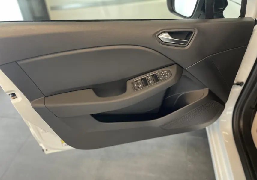 Porte avant gauche ouverte de la Renault Clio blanche, avec commandes électriques des vitres et poignée intégrée.