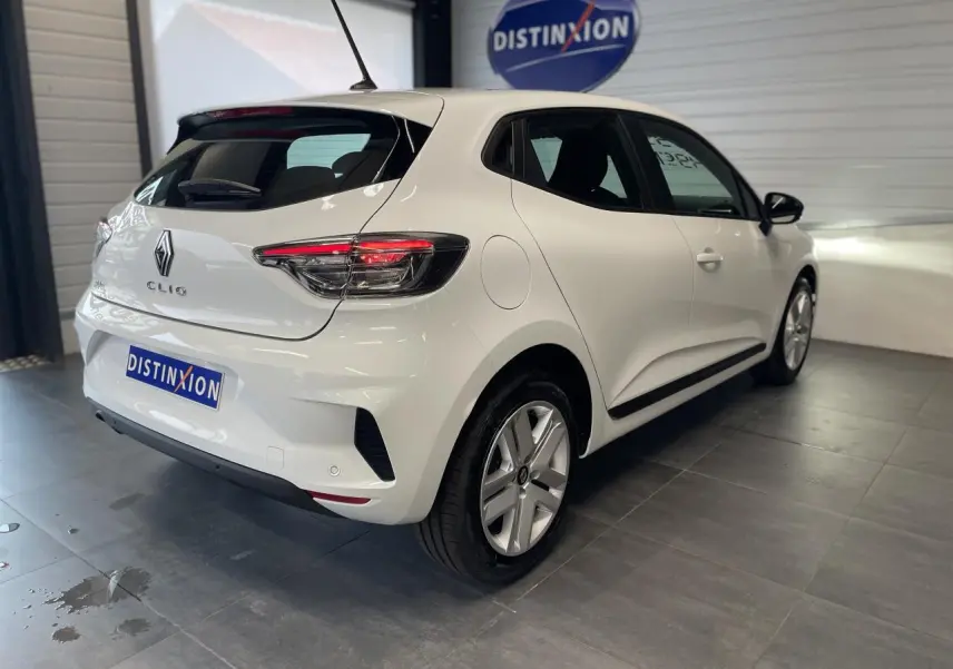 Renault Clio blanche vue 3/4 arrière droit en intérieur avec feux arrière LED et jantes alliage.